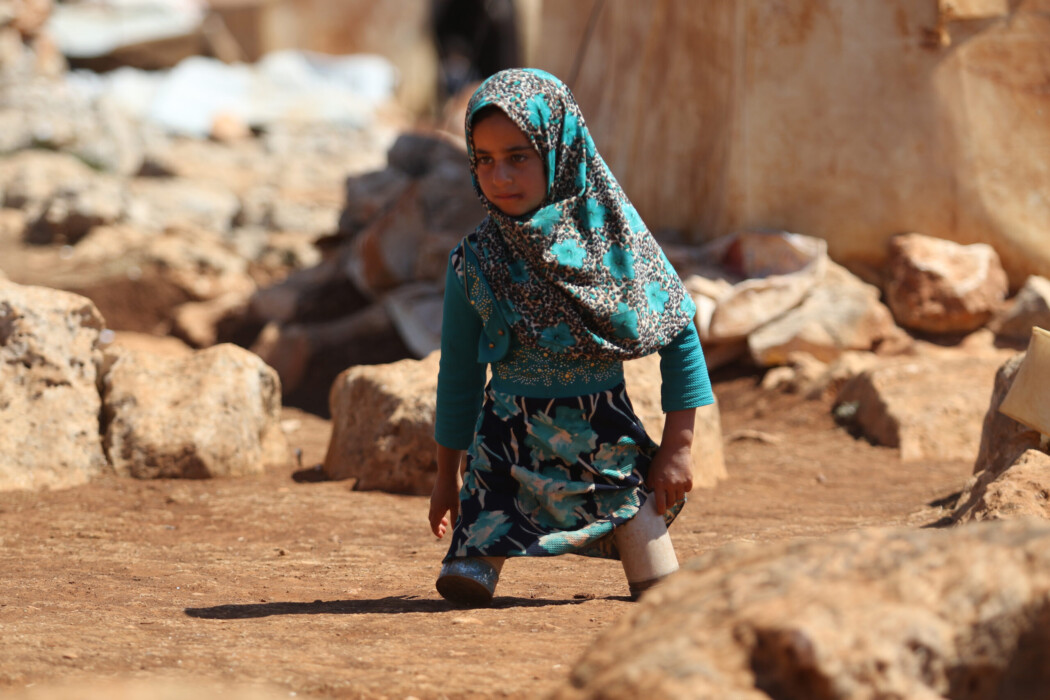 Eight year-old Maya Mohammad Ali Merhi walks using prosthetic legs made by her father from tin cans in a camp for displaced people, in the northern Syrian province of Idlib on June 20, 2018. - Maya and her father were both born without lower limbs. Unable to afford real prosthetic limbs, her father made her a pair out of tin cans filled with cotton and scrap pieces of cloth. Maya's family had to leave their home in the Aleppo province to flee battles. (Photo by Aaref WATAD / AFP)